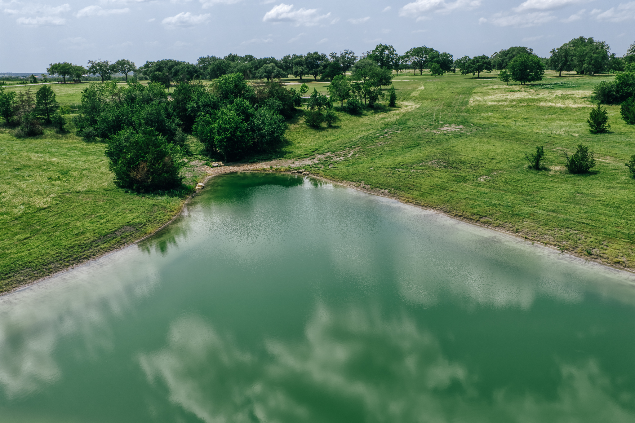 Aerial of Lot 4 — green pond foreground, open fields